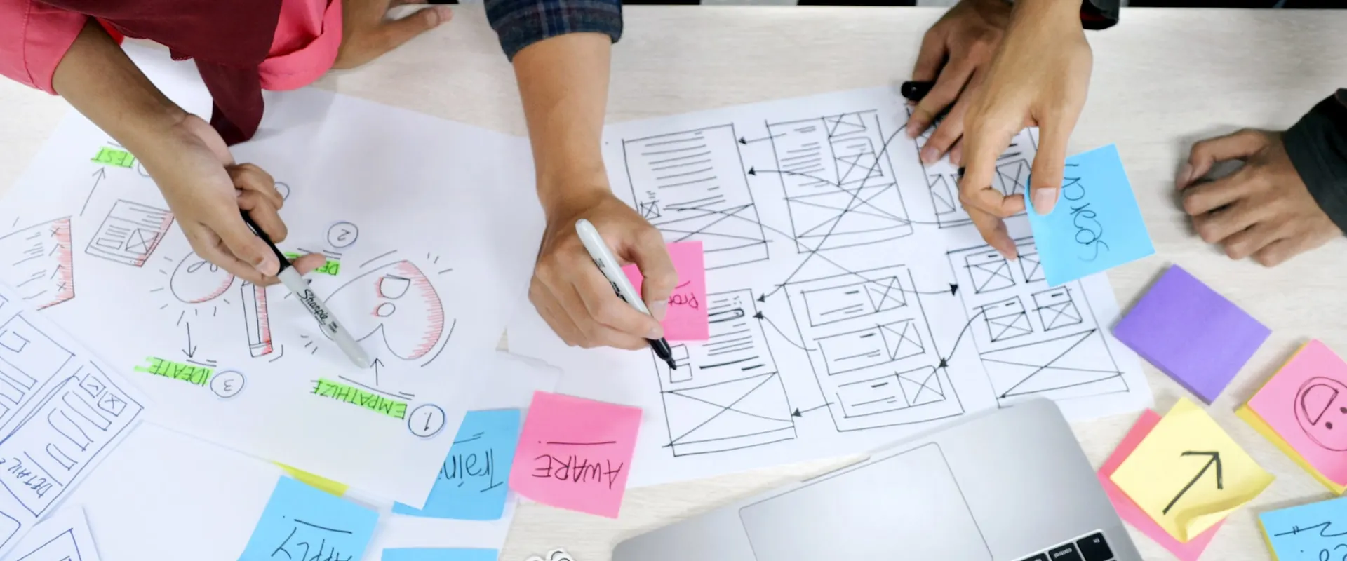 Equipo dibujando wireframes con notas adhesivas