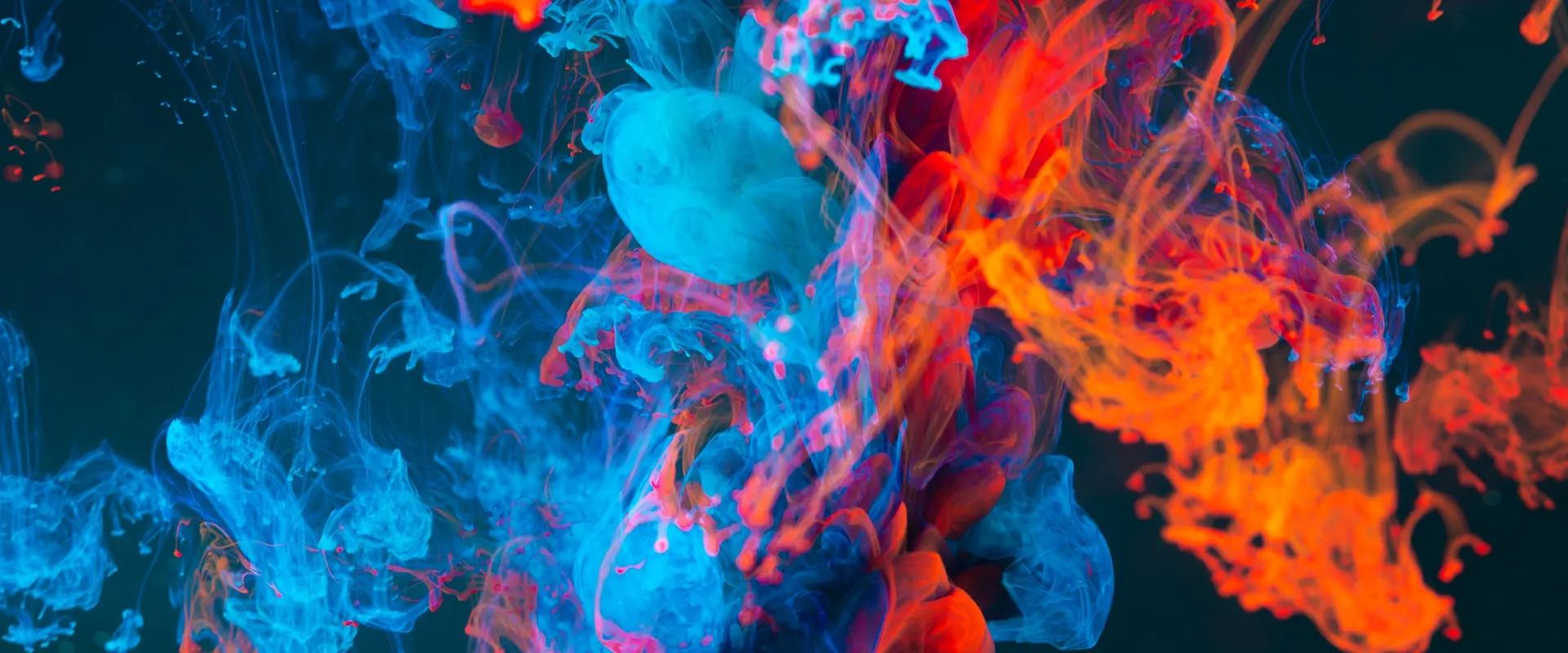 Tinta azul y naranja dispersándose en el agua